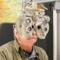 Client lors d'un examen de la vue au réfracteur chez Churchill Optique à Uccle